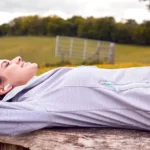 Una estudiante de oposiciones descansa escuchando música en la naturaleza