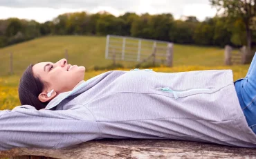 Una estudiante de oposiciones descansa escuchando m&uacute;sica en la naturaleza